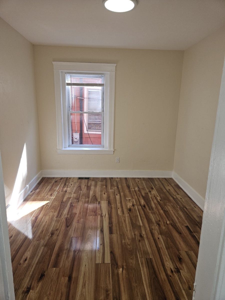 Bedroom with warm wood flooring at 30 Thorne Street, Apartment 1