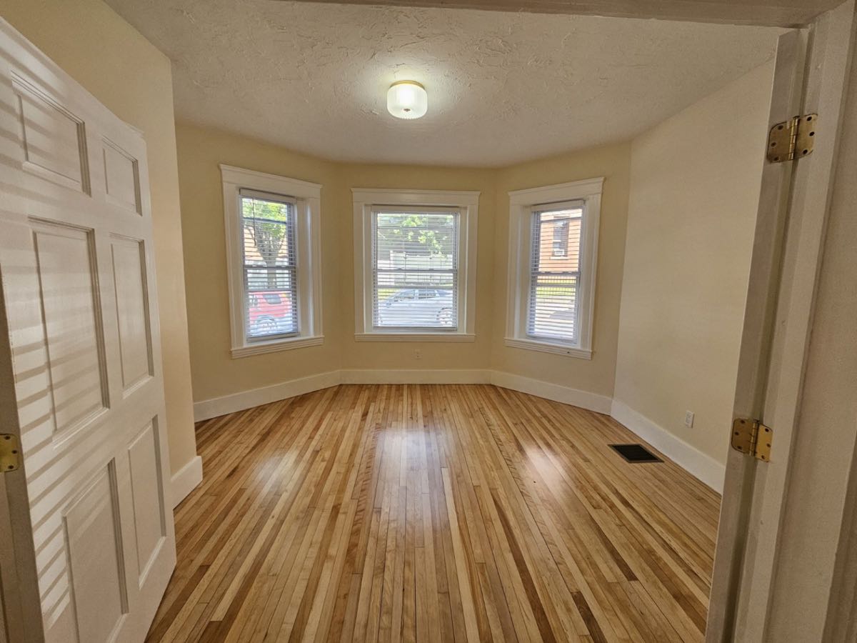 Bright living room with bay windows and refinished hardwood floors at 30 Thorne Street, Apartment 1